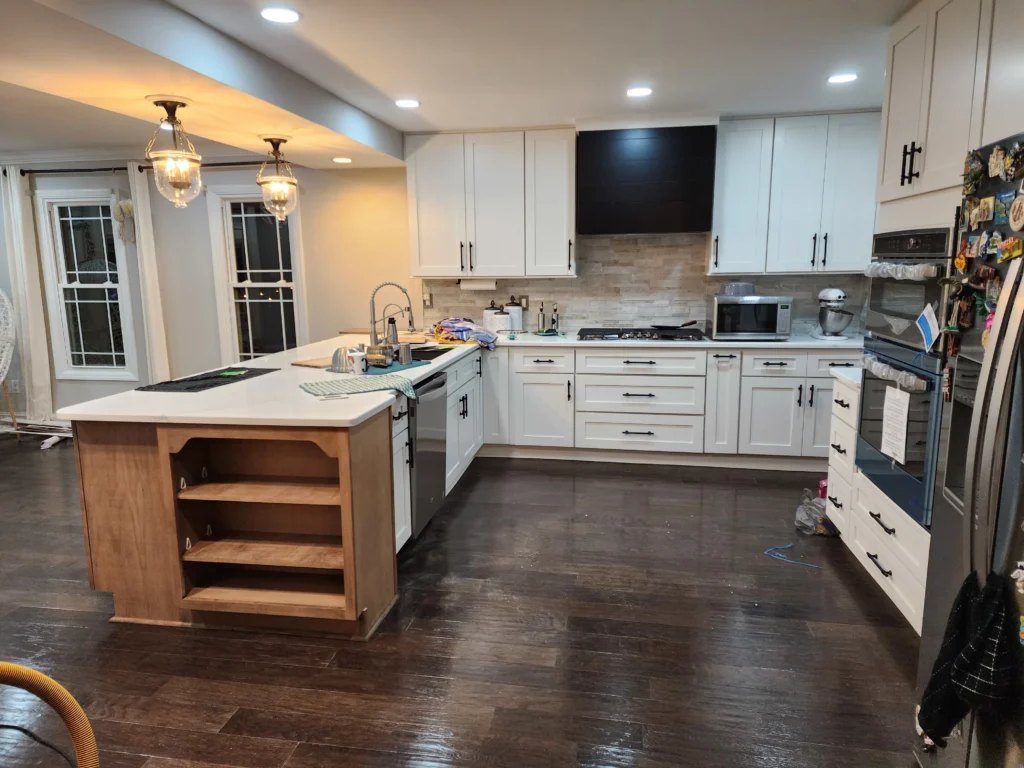 Kitchen with white cabinetry, central island and dark wood floors
